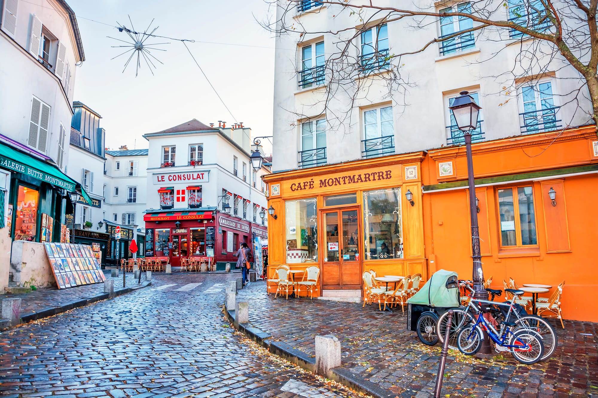 Cobblestone street in the Montmartre district of Paris with cafes and galleries